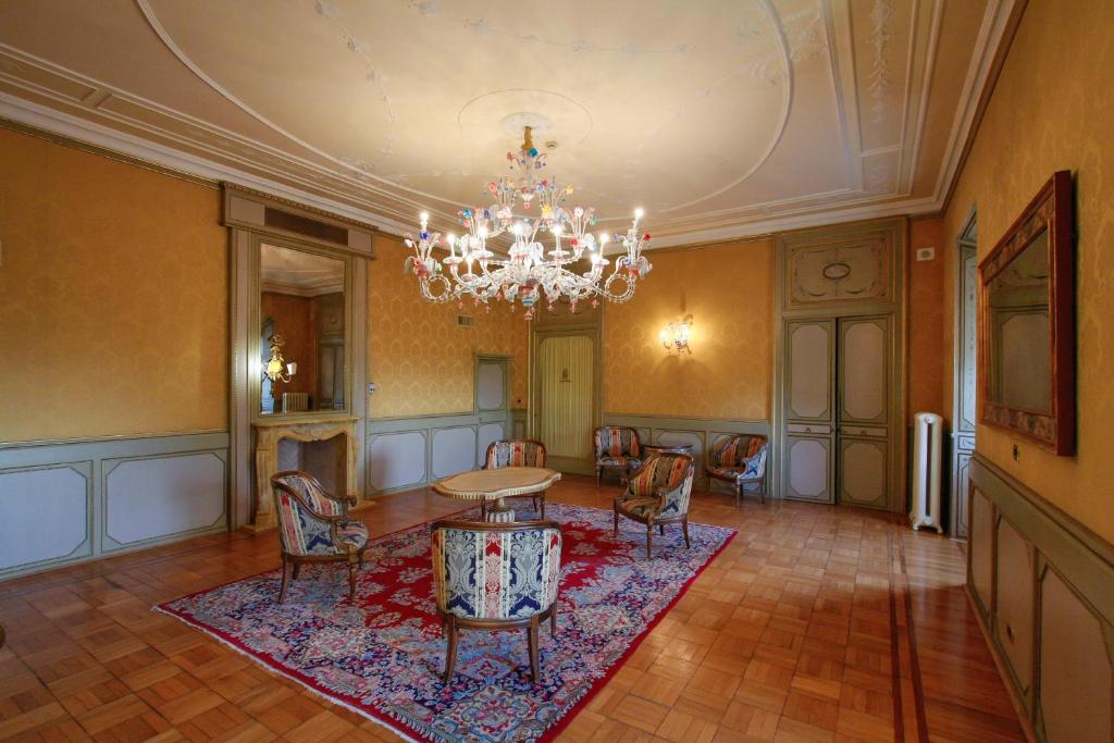 a room with a chandelier and a table and chairs at Park Hotel Villa Potenziani in Rieti