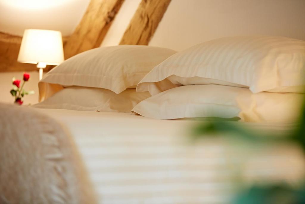 a bedroom with a bed with pillows and a lamp at Hameau de Blagny in Puligny-Montrachet