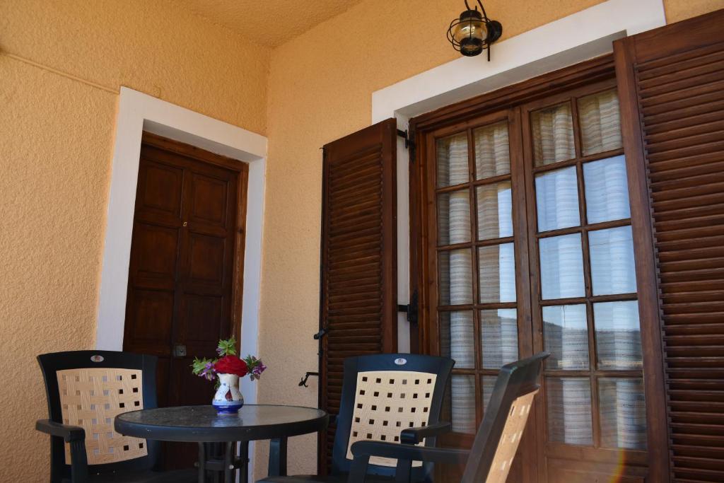 a dining room with a table and chairs and a window at Eriketi Studios in Agia Marina Aegina