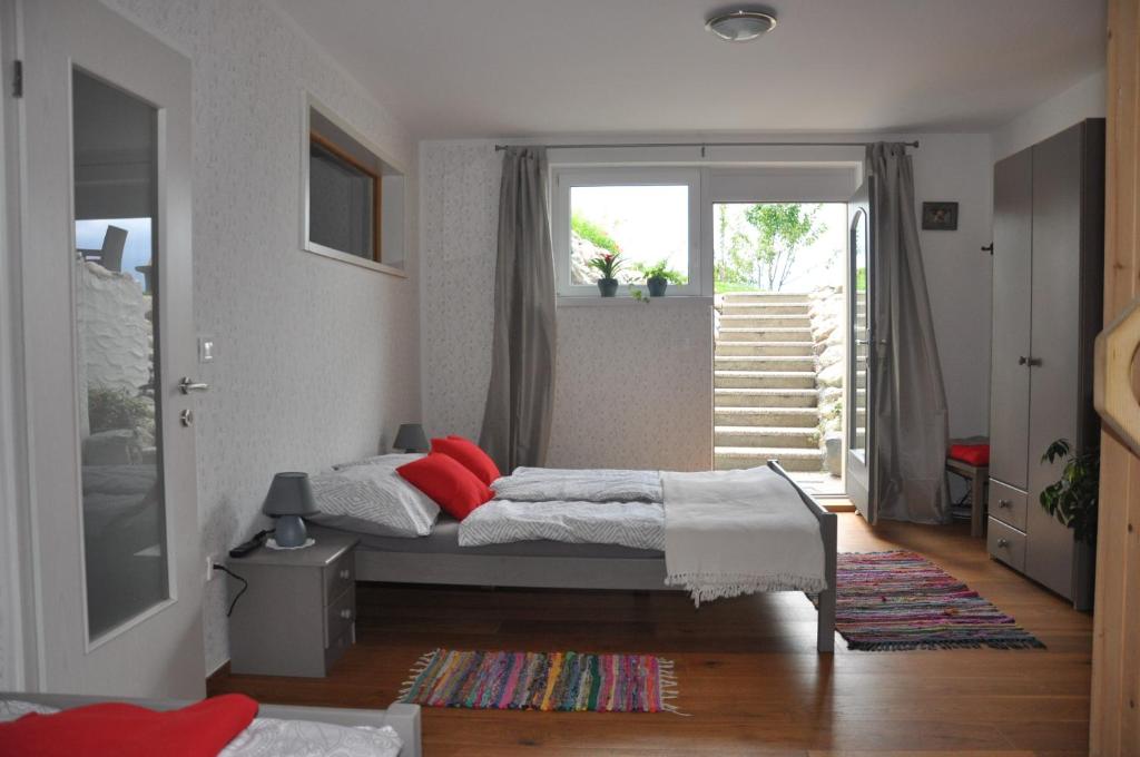 Un dormitorio con una cama con almohadas rojas. en Apartma Romana, en Spodnji Otok