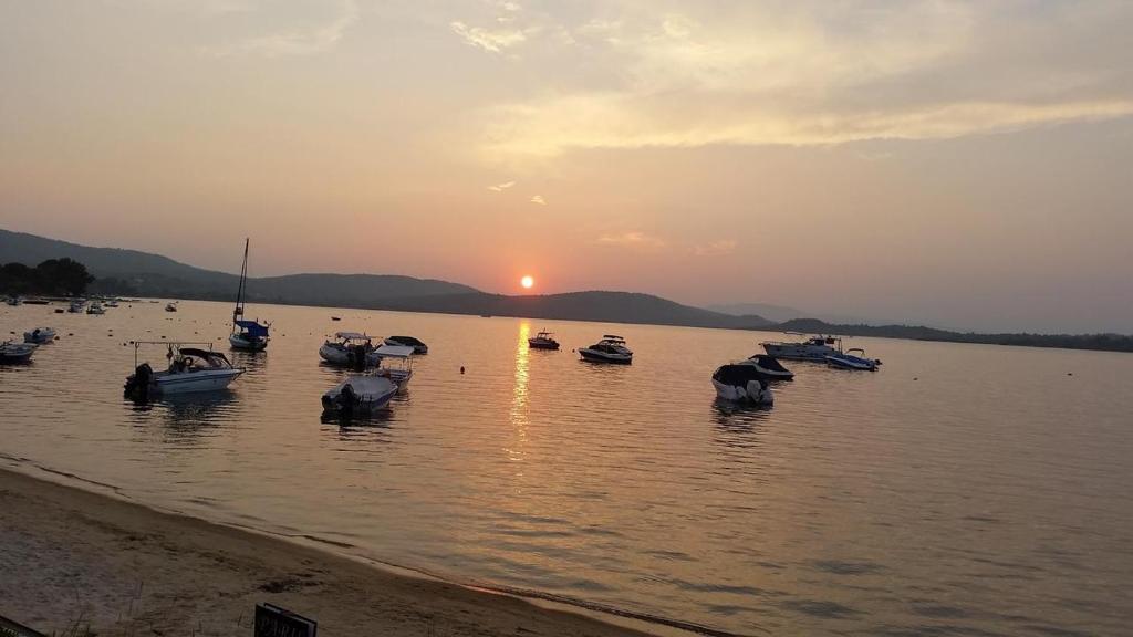 a group of boats in the water at sunset at Dasea Houses in Ormos Panagias