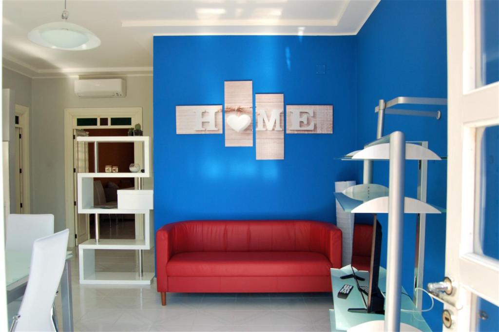 プラーイア・ア・マーレにあるL'appartamentoの青い壁の部屋の赤いソファ