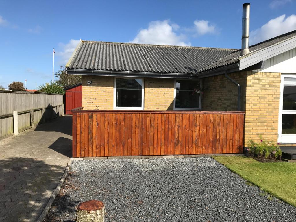 a house with a wooden gate in the driveway at Skagen Annex Apartment in Skagen