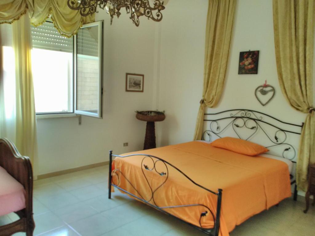 ルッファーノにあるNel Giardino di Isabelのベッドルーム1室(オレンジ色のベッド1台、窓付)