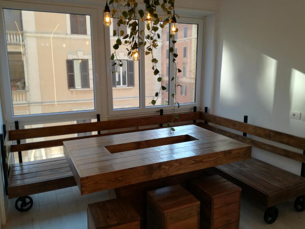 a large wooden table in a room with a window at My Tiny Home in Rome