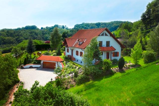 een wit huis met een rood dak in een veld bij Landhaus zur Therme in Jennersdorf