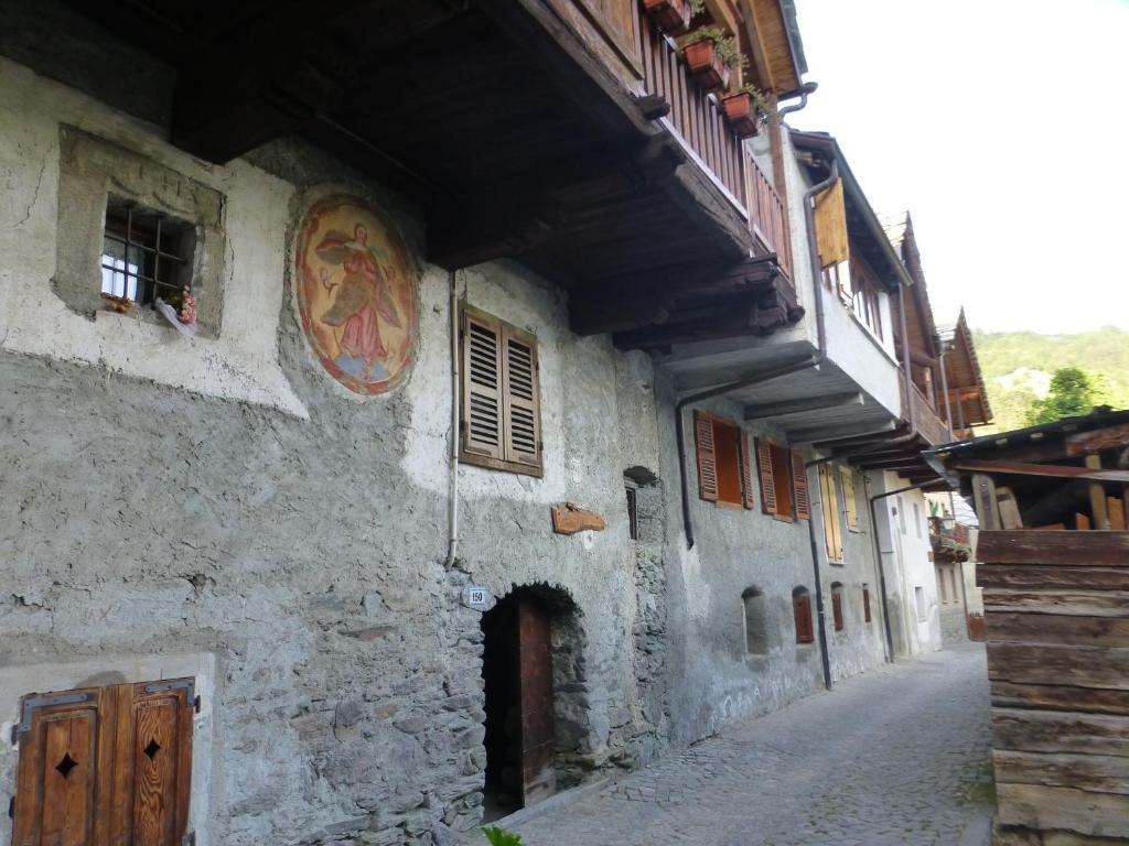 an old building with a painting on the side of it at Casa Nemesis in Brusson