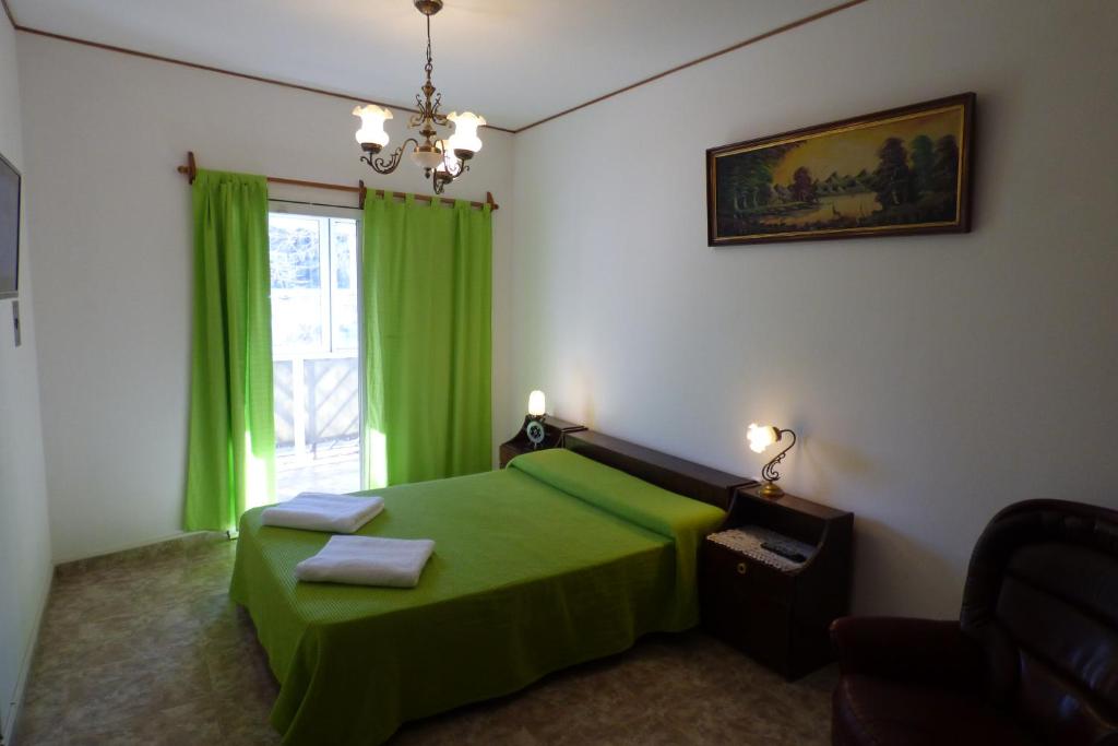 a bedroom with a green bed and a window at Departamento Centrico in Villa Carlos Paz