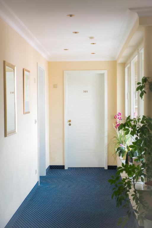 a hallway with a white door and a plant at Hotel Landgasthof Birkenfelder Hof in Birkenfeld