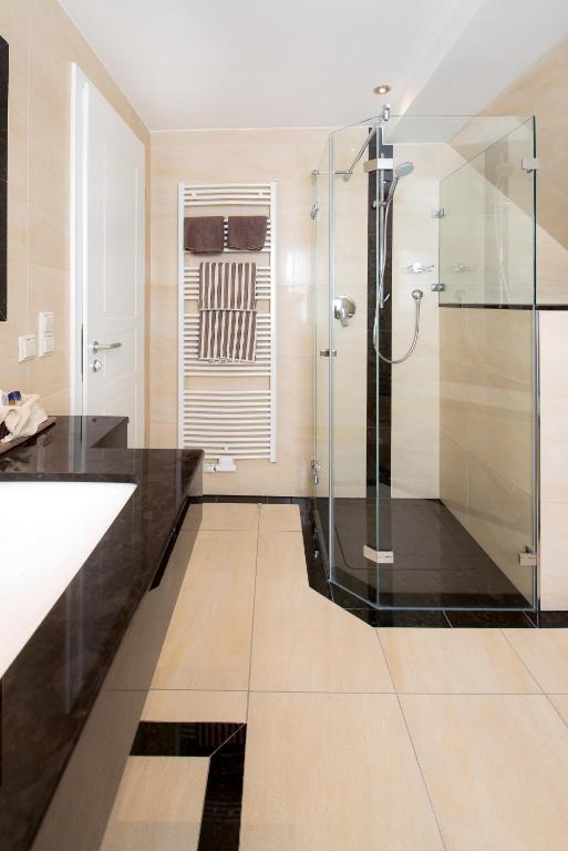 a bathroom with a shower and a glass shower stall at Hotel Landgasthof Birkenfelder Hof in Birkenfeld