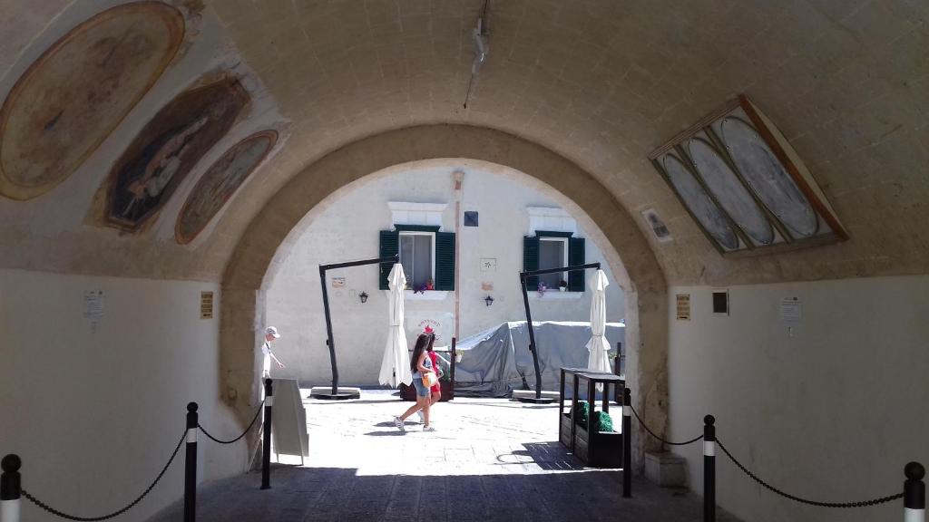 a woman walking through an archway in a building at Casa Vacanza Martino in Matera