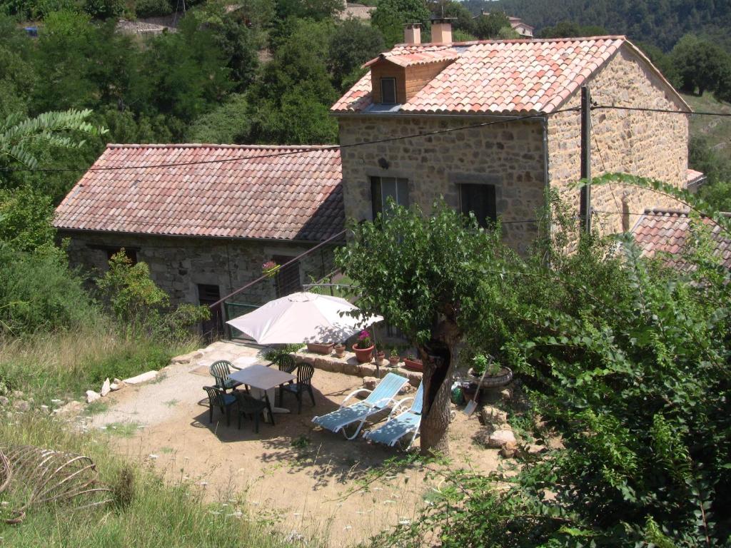 a house with a table and chairs in front of it at maison de la salamandre in Ribes