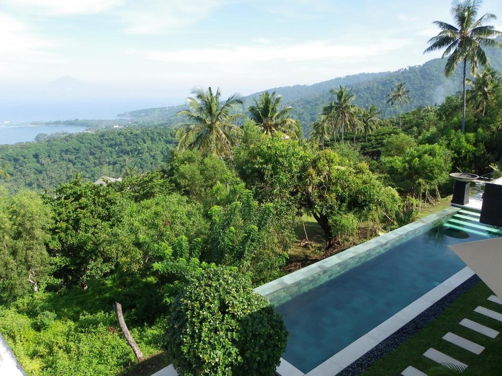 a swimming pool with a view of the jungle at The Puncak Lombok in Senggigi