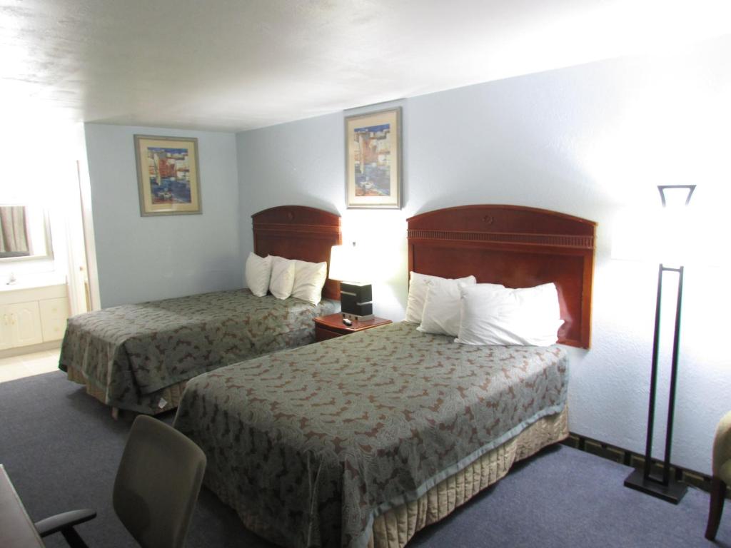 een hotelkamer met 2 bedden en een stoel bij Parsons Inn Downtown Parsons,Tn in Parsons