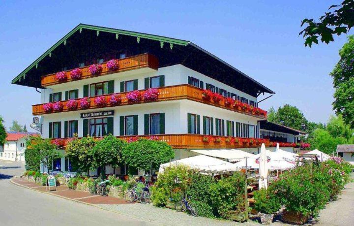 Un bâtiment avec beaucoup de fleurs sur lui dans l'établissement Hotel Unterwirt, à Eggstätt