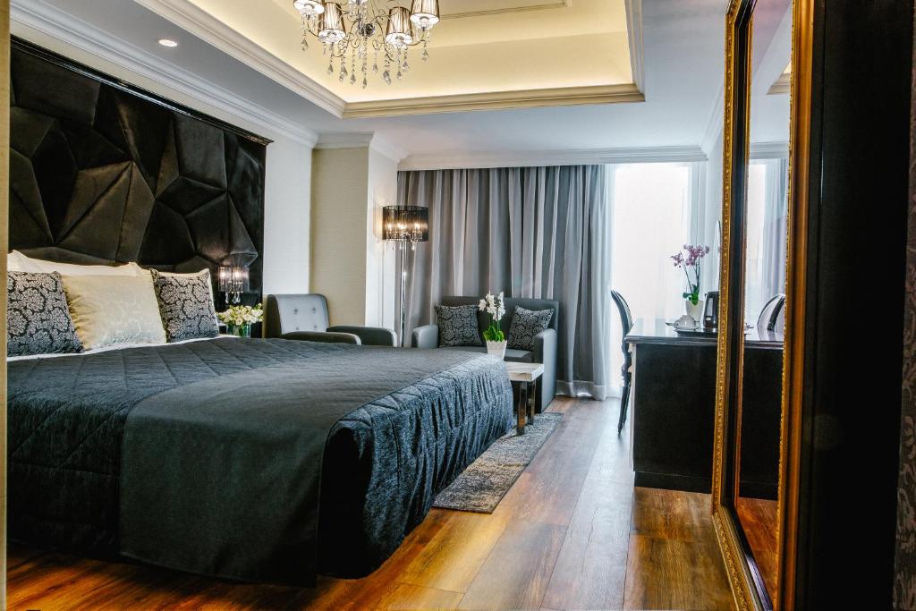 a bedroom with a large bed and a living room at Qbic City Hotel in Larnaca