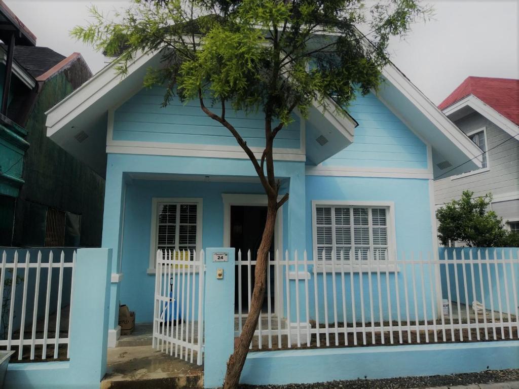 a blue house with a white fence and a tree at Homestay at 24 Laguna Bel-Air by Red Door House Rental in Santa Rosa