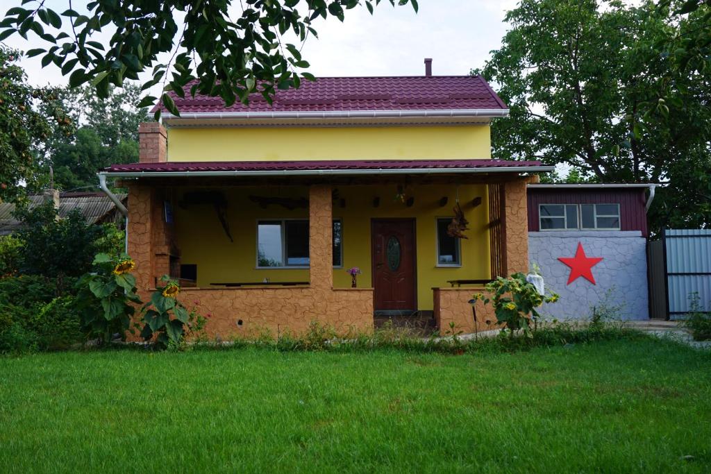 a small yellow house with a red star on it at Red Star Peoples Republic in Tiraspol