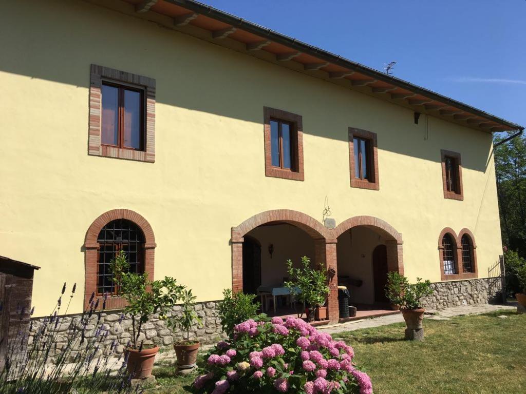 - un grand bâtiment avec des fenêtres et des fleurs dans une cour dans l'établissement La Maroneta, à Pistoia