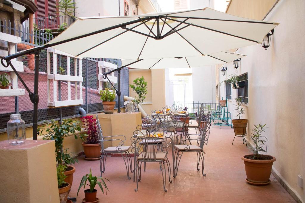 パレルモにあるBagnasco 18 suite&terraceのパティオ(大きなパラソルの下にテーブルと椅子付)