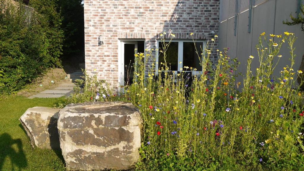 un giardino fiorito di fronte a un edificio di Studio im Haus in Seenähe a Reinfeld