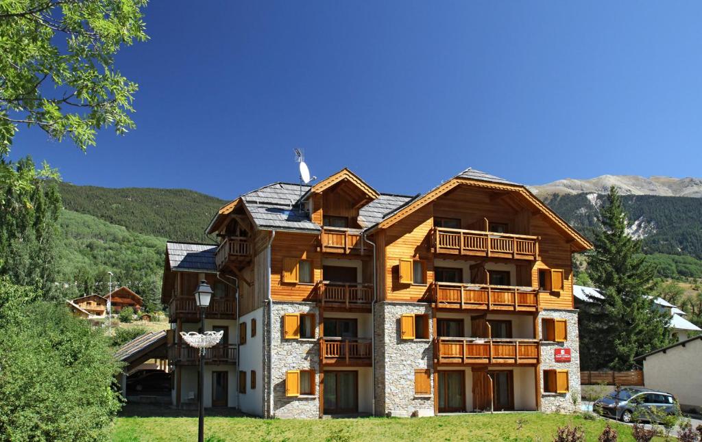 un gran edificio de madera con techo en Résidence Le Chalet de L'Eterlou by Popinns en Saint-Chaffrey