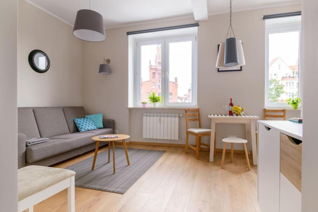 sala de estar con sofá y mesa en Plac Wielkopolski Apartment en Poznan