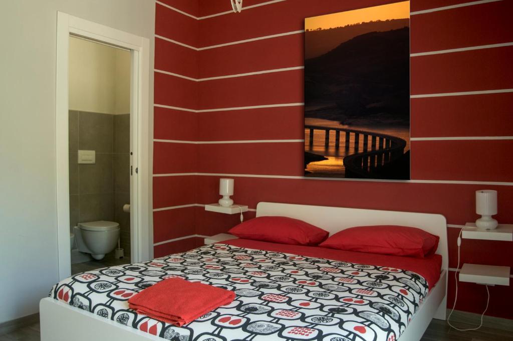 Nelle Stanze Del Matese في Boiano: غرفة نوم حمراء مع سرير بجدران حمراء