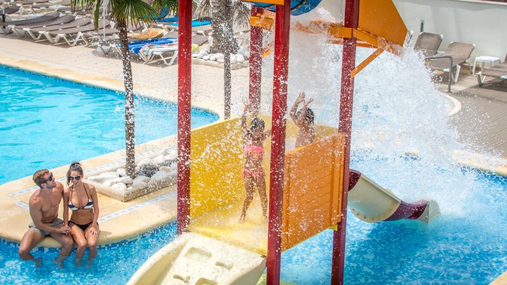 甘迪亞的住宿－RH拜仁公園酒店，一群人在游泳池的水滑梯上玩耍