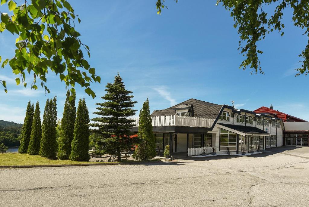 a large house with a tree in front of it at Kongsvinger Budget Hotel in Kongsvinger