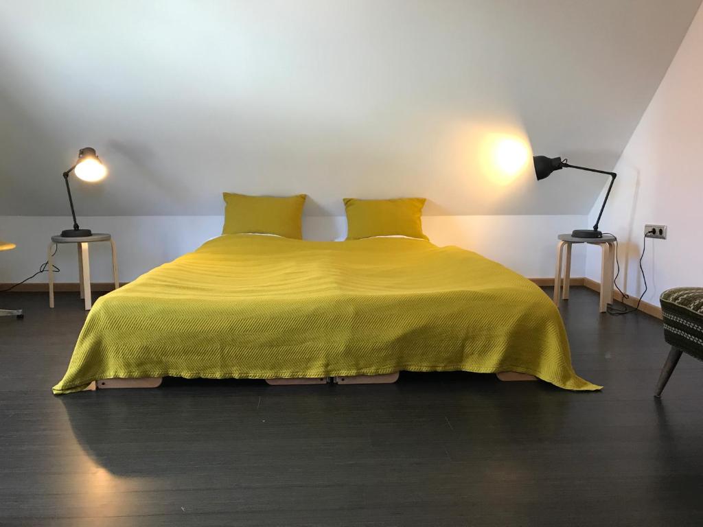 a bedroom with a yellow bed with two yellow pillows at Blackbird´s Nest in Wiesenbronn