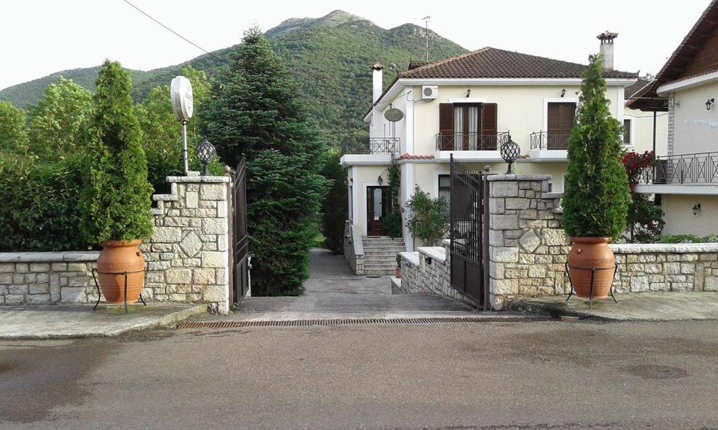 a house with a gate and a stone wall at Aroanios Hotel in Klitoria