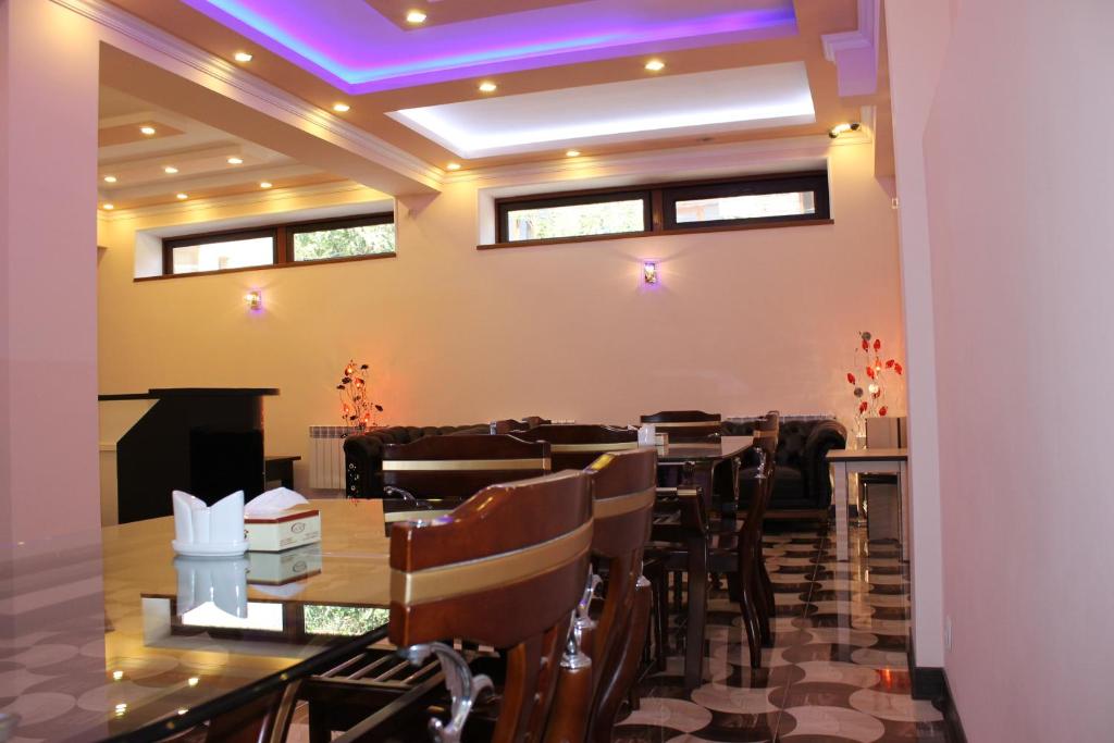 uma sala de jantar com mesas e cadeiras e uma lareira em Hotel For You em Yerevan