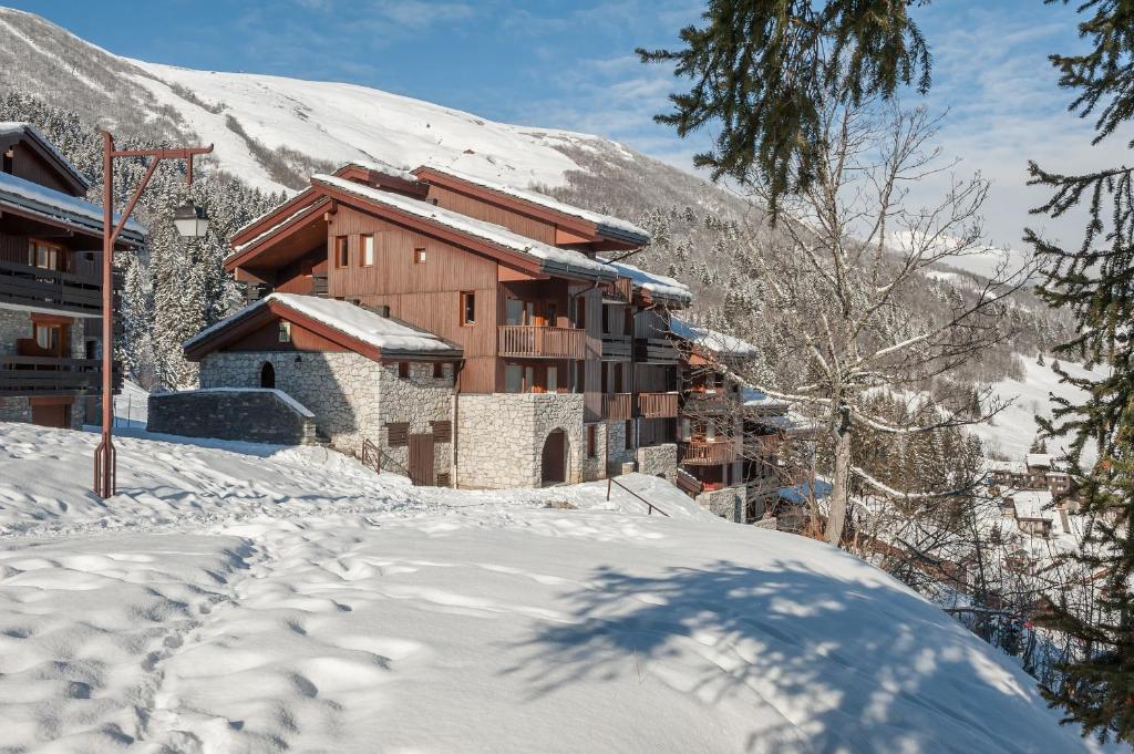 un lodge de ski dans la neige avec une montagne dans l'établissement Quartier Crève Cœur - maeva Home, à Valmorel