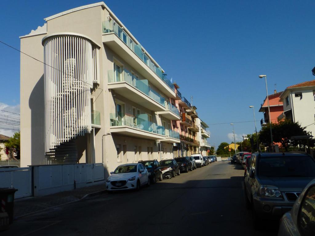 una macchina bianca parcheggiata di fronte a un edificio di A Due Passi dal Mare a Civitanova Marche