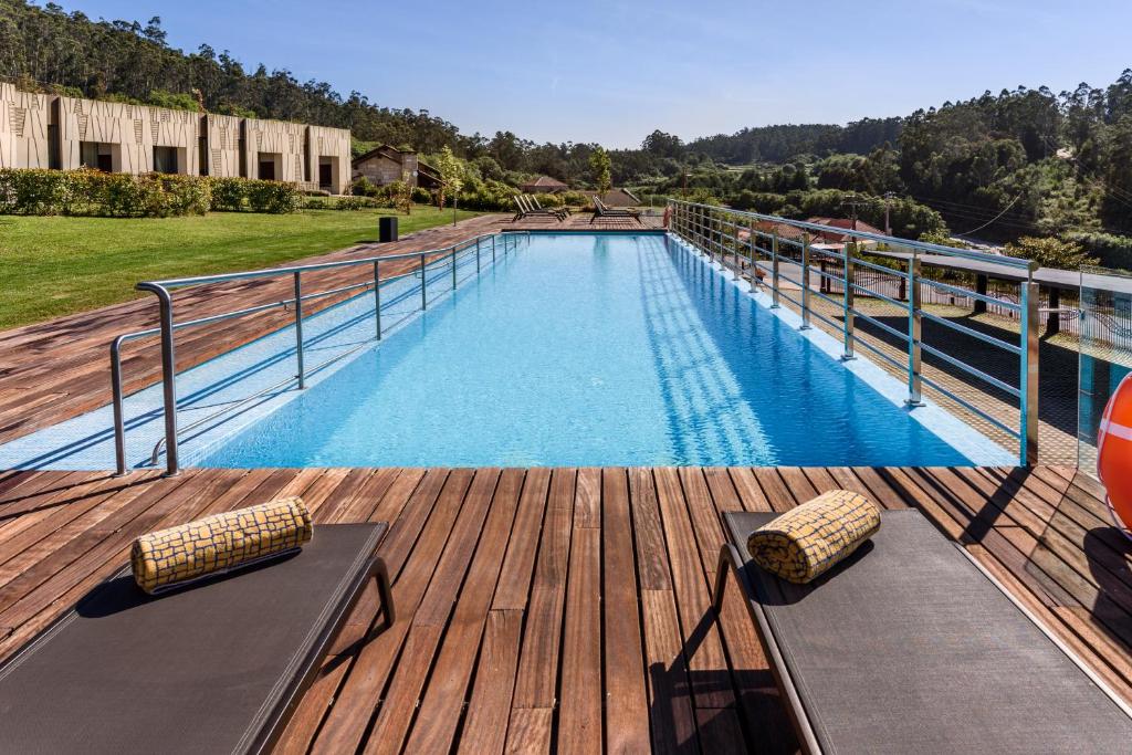 a large swimming pool on a wooden deck at Pousada Armenteira in Pontevedra