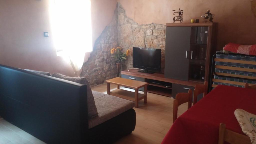un soggiorno con divano e TV di Apartment Fabris a Vrsar