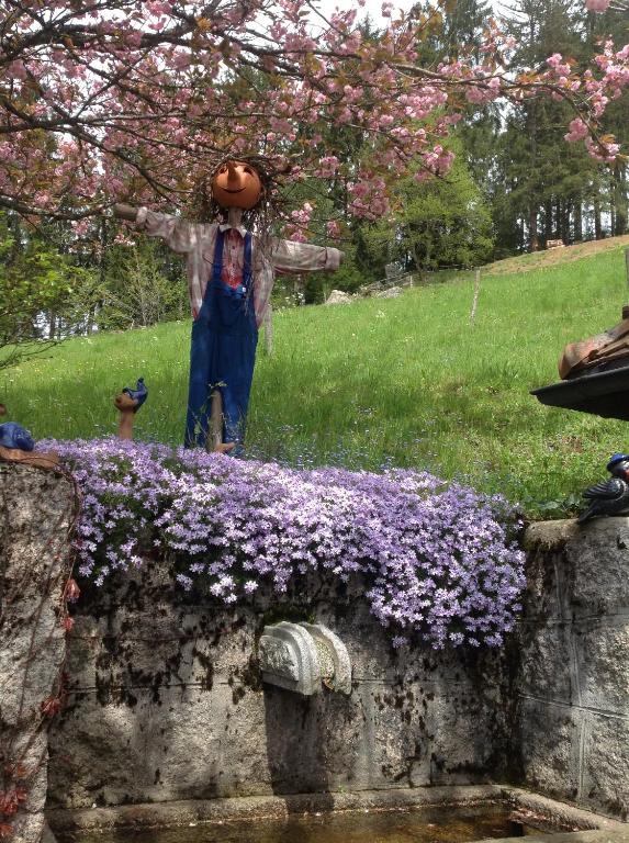 a statue of a girl with a pumpkin on top of flowers at Holzbildhauerei Kammerer in Triberg