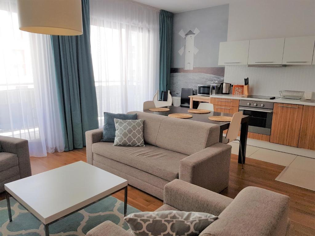 a living room with a couch and a kitchen at AGAT Apartamenty in Świnoujście