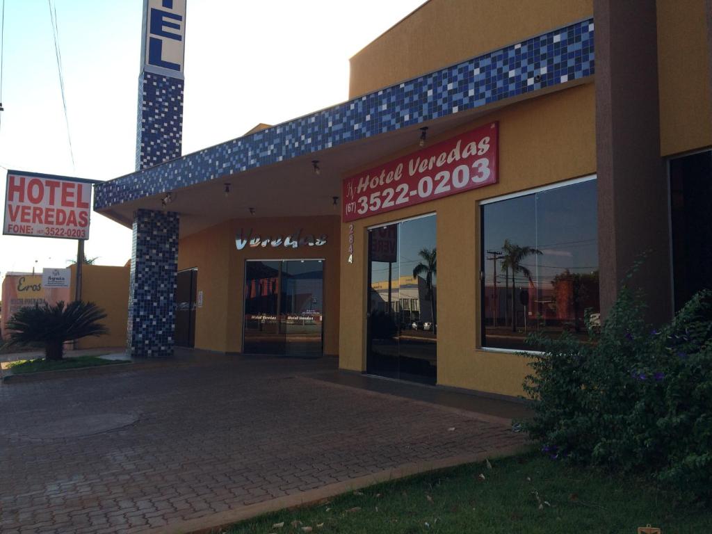 a hotel with signs on the front of a building at Hotel Veredas in Três Lagoas