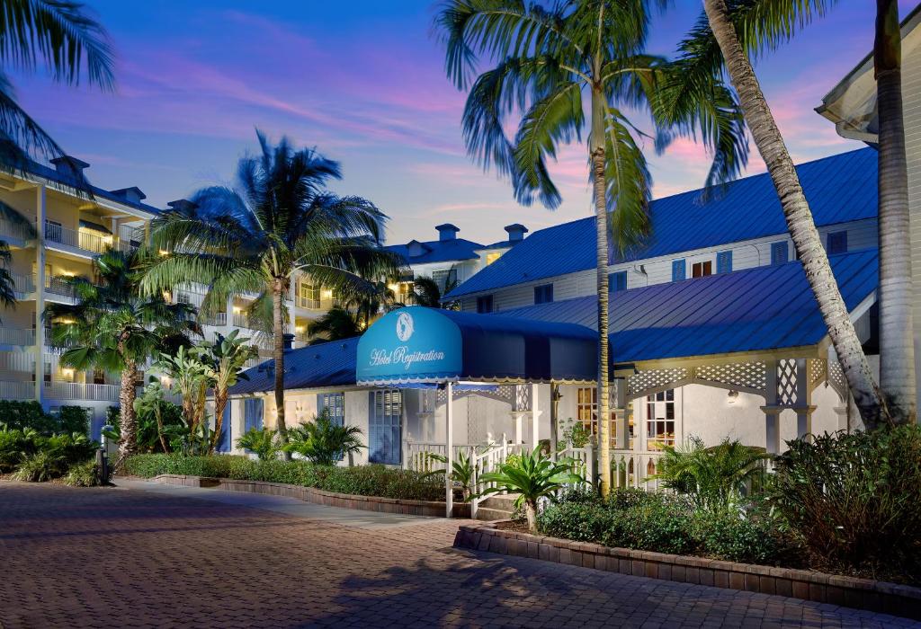 a hotel with palm trees in front of it at Olde Marco Island Inn and Suites in Marco Island