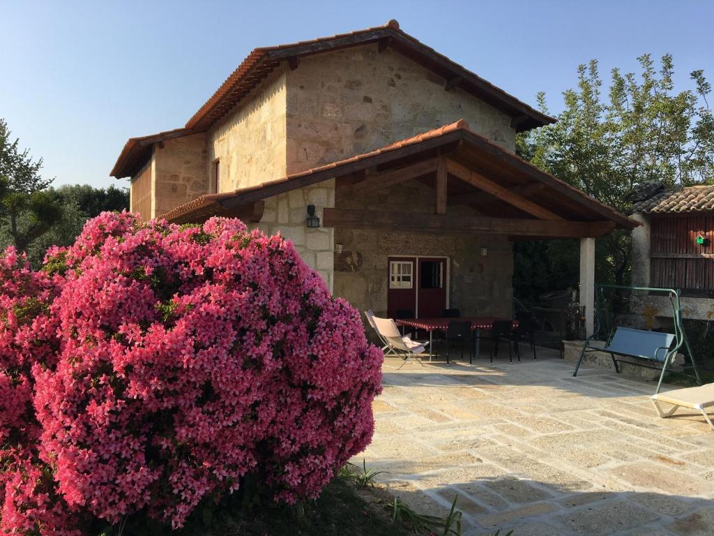 una casa con flores rosas delante de ella en Casa de Romao, en Amares