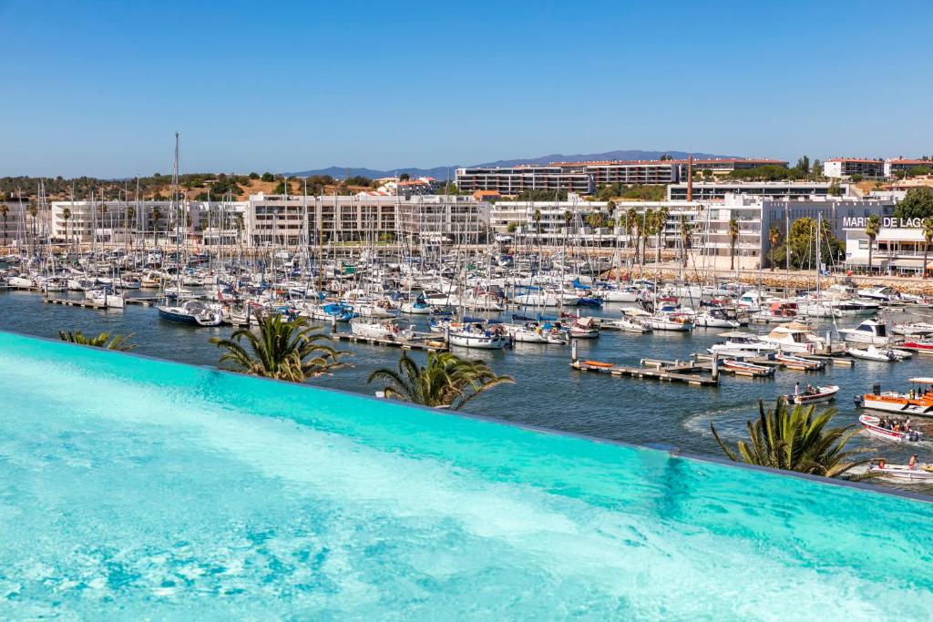 a swimming pool in front of a marina with boats at Lagos Avenida Hotel in Lagos