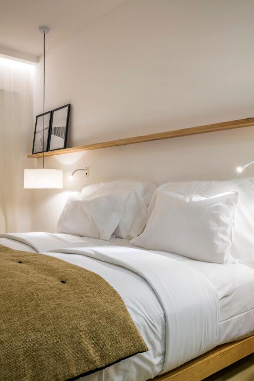 a large bed with white sheets and pillows at Lagos Avenida Hotel in Lagos