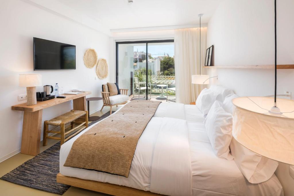 a bedroom with a large white bed and a desk at Lagos Avenida Hotel in Lagos