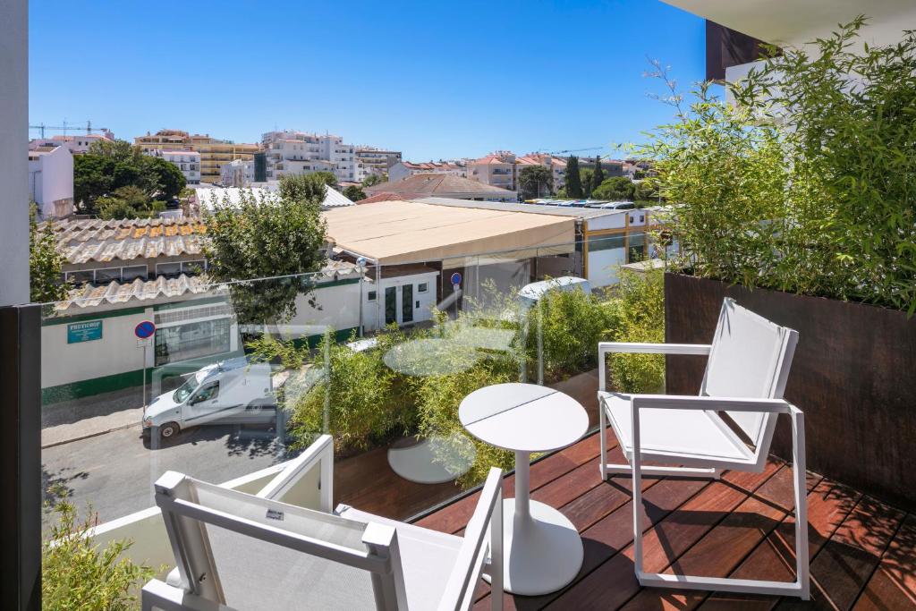 a balcony with chairs and a table and a view of a city at Lagos Avenida Hotel in Lagos