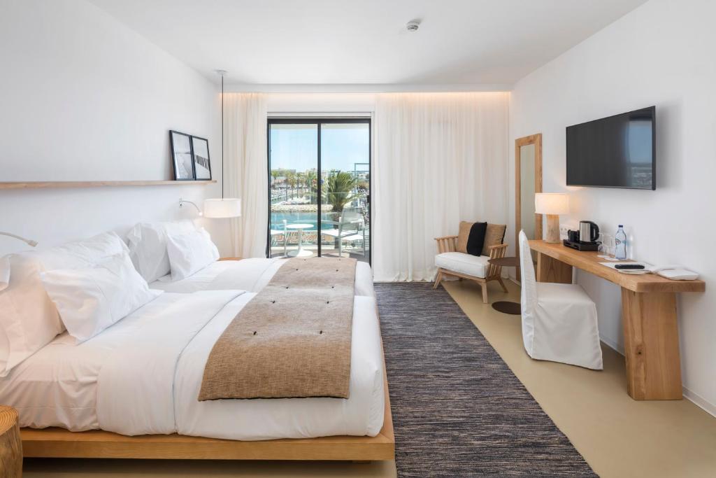 a bedroom with a bed and a desk and a television at Lagos Avenida Hotel in Lagos