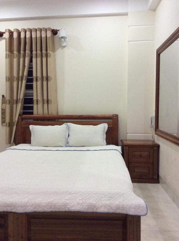 a bedroom with a bed and a mirror at Hoang Oanh Hotel in Quy Nhon