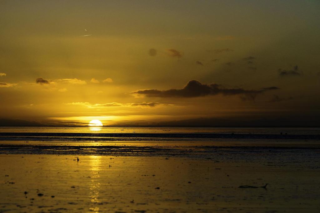 un tramonto sulla spiaggia con il tramonto di Muschelsucher a Norden