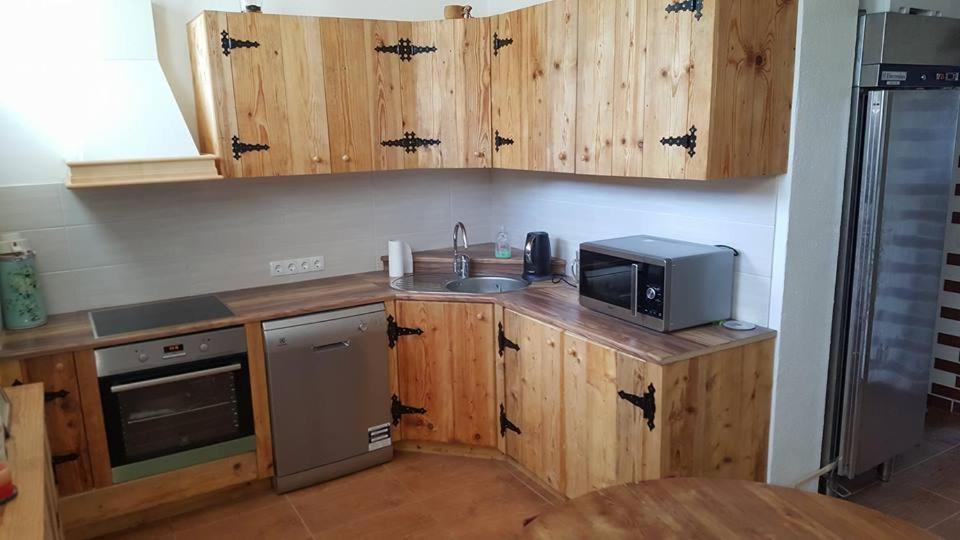 Kuchnia z drewnianymi szafkami, zlewem i kuchenką mikrofalową w obiekcie Järva Jahindusklubi HOSTEL w mieście Paide